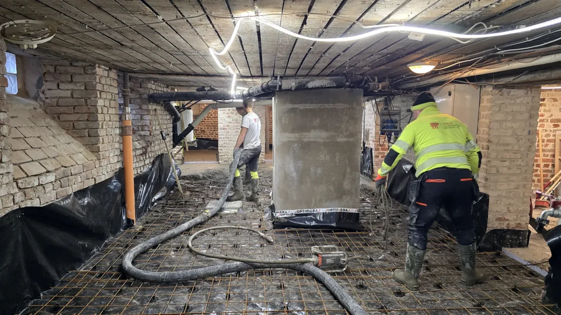 ansatte som legger betong på kjellergulv