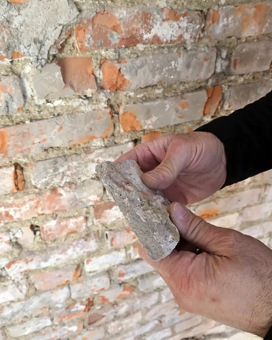 ansatt som holder sementbasertfasadepuss